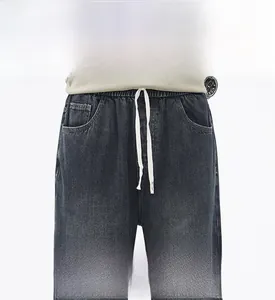 Dettaglio dei jeans in denim grigio con elastico in vita e coulisse bianca da uomo