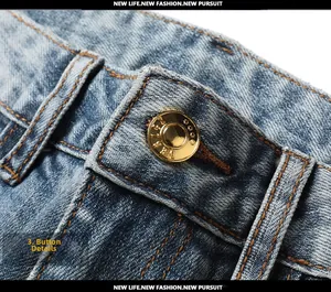 Macro view of light blue denim waist featuring a gold metal button and fine stitching