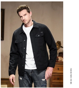 Detail of men's slim fit black denim jacket with chest pockets and classic lapel collar