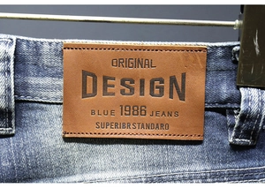 Dettaglio dell'etichetta in pelle marrone sui pantaloncini di jeans lavati con rilievo