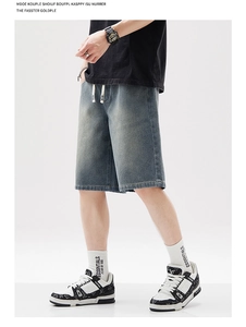 Détail de la texture du denim et du cordon de serrage blanc sur le short bleu large
