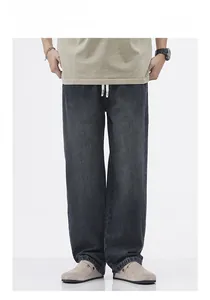 Dettaglio di jeans grigi vintage lavati con vita elastica e coulisse bianca