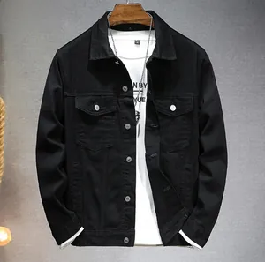 Detail shot of black denim jacket with silver buttons and chest pockets on wooden hanger