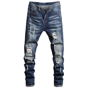 Men's slim fit distressed blue jeans with street style paint splatters and fringe detail