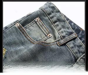 Gros plan détaillé sur la poche en jean avec doubles coutures jaunes et rivets métalliques