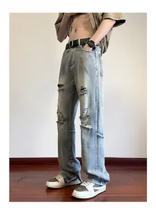 Dettaglio dei jeans lavaggio azzurro con cerniera laterale e orlo con effetto strappato