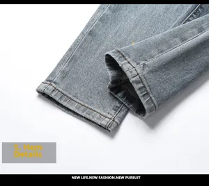 Close-up of hem details on light blue washed slim fit denim jeans with neat stitching