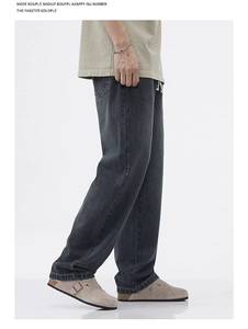 Dettaglio dei jeans a gamba larga grigio scuro lavati con coulisse in vita e texture usurata