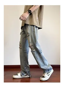 Dettaglio dei jeans azzurri strappati con cerniere laterali e texture effetto usurato