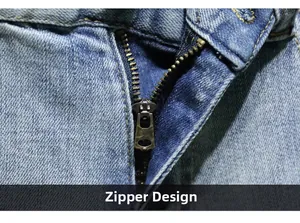 Detailed macro view of bronze metal zipper on light blue vintage washed denim fabric