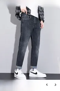 Detail of dark gray blue slim fit men's jeans with vintage wash and cuffed hem