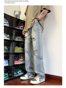Dettaglio macro dei jeans blu da uomo con strappi consumati e cerniere laterali sul fondo
