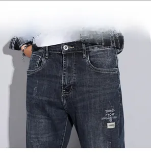 Detail of dark blue denim jeans showing whiskering and triangle embroidery patch
