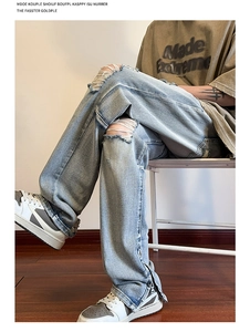 Dettaglio di jeans azzurri strappati con strappi sulle ginocchia e zip laterali
