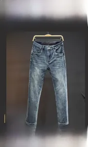 Detailed view of men's slim straight jeans featuring natural wash and classic five-pocket style