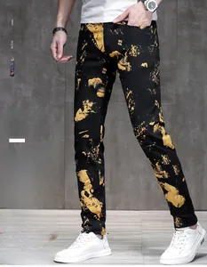 Detail view of men's slim fit black pants with gold splash ink pattern and warm fleece lining