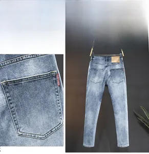 Detail of red jeans fashion woven label on back pocket of washed slim fit blue denim pants