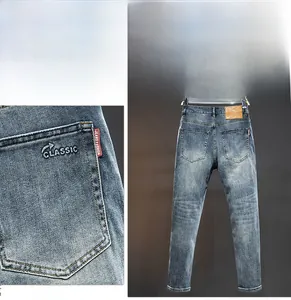 Detail of classic denim jeans with rear pocket embroidery and brown leather waist patch