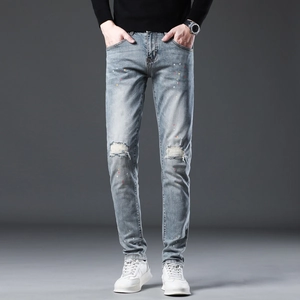 Slim fit light blue distressed jeans with knee holes and colorful paint splatter accents