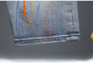 Detail view of denim shorts hem featuring vintage wash and colorful paint splatter effect