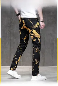 Dettaglio dei jeans da uomo slim fit con motivi a spruzzo gialli in stile streetwear