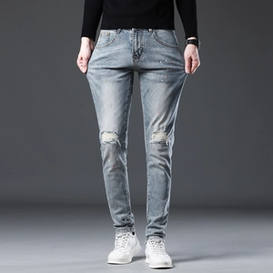 Men's slim fit distressed blue jeans with ripped knees and colorful paint splatter details