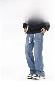 Détail d'un jean ample bleu clair rétro avec des cordons de serrage blancs à la taille