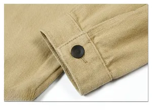 Macro detail of khaki twill cotton jacket cuff featuring a neat black resin button