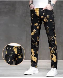 Dettaglio di pantaloni neri slim fit da uomo con stampa a spruzzo gialla trendy