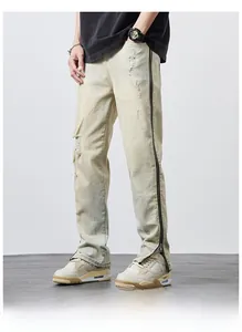 Detail of vintage washed denim jeans with distressed holes and side metal zipper design