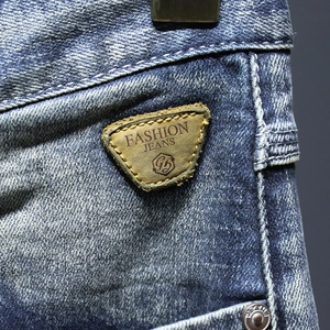 Primo piano di pantaloncini di jeans da uomo vestibilità ampia con toppa in pelle