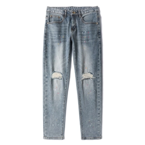 Slim fit light blue distressed jeans with stylish paint splatters and ripped knees