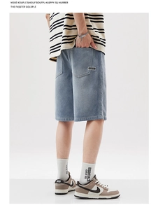 Détail d'un short en jean bleu clair ample avec une étiquette noire CHUTES sur la poche