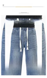 Détail du jean bleu clair montrant la taille haute avec des cordons plats blancs
