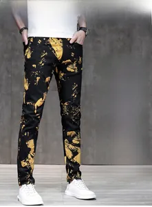Vista dettagliata dei jeans neri slim con vivaci motivi a spruzzo di vernice gialla