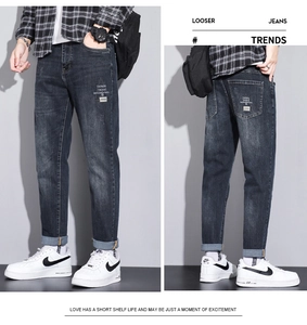 Detail view of dark blue stretch denim jeans with distinctive lettered triangle patches