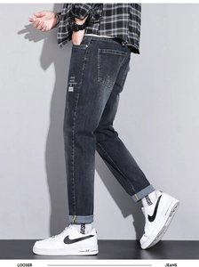 Detail of dark grey washed denim pants with white geometric street style side print