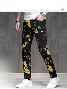 Detail view of men's slim fit black jeans with artistic yellow splash print and fleece lining