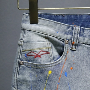Men's retro light blue washed denim shorts with artistic colorful ink splash design