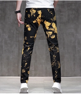 Jeans slim neri da uomo con stampa artistica a spruzzi di vernice gialla vista retro