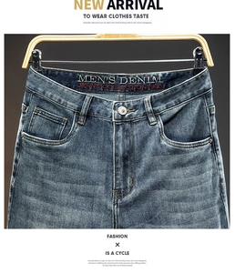 Detail of premium men's denim jeans featuring vintage wash cat whiskers and inner waist print