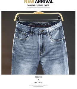 Detailed macro shot of vintage washed blue denim jeans with metal button and whiskering effect