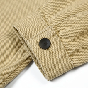 Close-up of khaki twill cotton jacket cuff with adjustable black button and detailed stitching