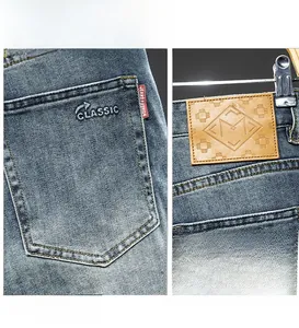 Detail of light blue denim jeans with classic embroidery and embossed leather waist logo