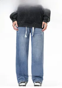 Détail du jean denim bleu clair délavé avec texture vintage et cordon blanc à la taille