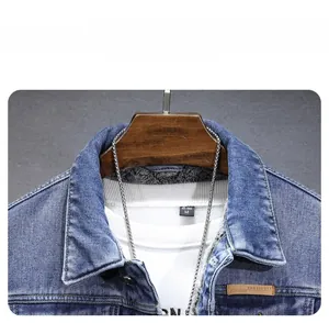 Détail d'une veste en jean bleue avec doublure en polaire grise et écusson logo