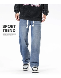Détail du jean en denim délavé bleu clair avec une taille à cordon de serrage pratique