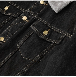 Close-up of black denim jacket with gray faux fur collar and bronze metal jeans buttons