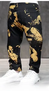 Dettaglio di jeans neri slim da uomo con stampe graffiti gialle e design delle tasche