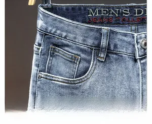 Detail of light blue washed denim jeans featuring curved pockets and metal rivets
